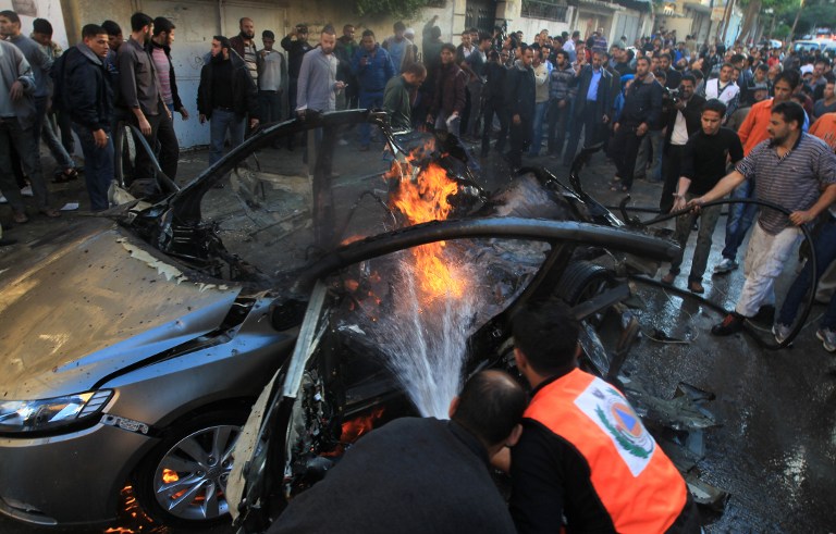 AIRSTRIKE AFTERMATH. Palestinian firefighters extinguish fire from the car of Ahmaed Jaabari, head of the military wing of the Hamas movement, the Ezzedin Qassam Brigades, after it was hit by an Israeli air strike in Gaza City on November 14, 2012. The top Hamas commander Ahmed al-Jaabari was killed in an Israeli air strike , medics and a Hamas source told . AFP PHOTO/MAHMUD HAMS