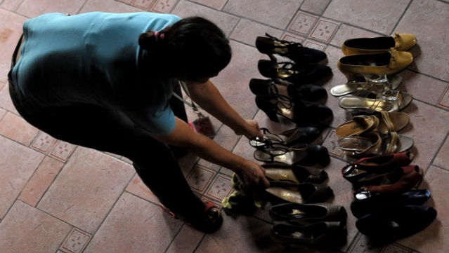 DAMAGED. Amid the deluge of Ondoy in 2009, a staffer at the Marikina Shoe Museum salvages Imelda’s shoes. Photo: Jay Directo/AFP