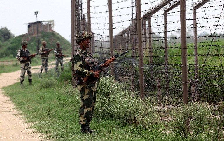 In this photograph taken on August 2, 2012 Indian Border Security Force (BSF) soldiers stand guard along fencing near the India-Pakistan Chachwal border outpost, some 65 kms north from the north-eastern Indian city of Jammu. AFP PHOTO/ STR /FILES