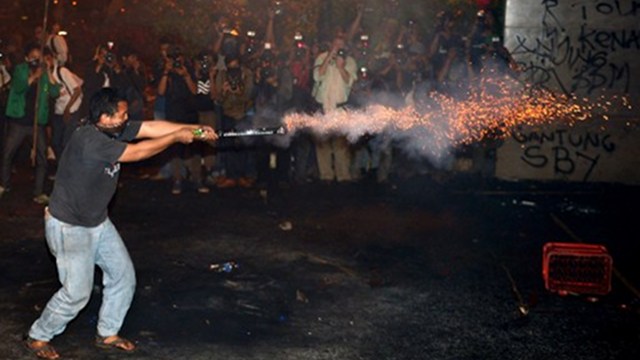 OIL POLITICS. An Indonesian student launches fireworks towards police during a protest against the fuel price hike outside parliament in Jakarta on June 17, 2013. Photo by AFP