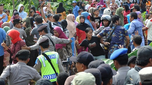 CHRISTMAS VIOLENCE. Indonesian police (C) block angry Muslim residents away from Christian worshippers from the Filadelfia Batak Christian Protestant intent on holding a Christmas mass on their property at the Jejalen Jaya village in Bekasi on December 25, 2012. Photo by AFP