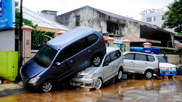 FLASHFLOODS, LANDSLIDES. Cars are seen on top of each after being hit by flood waters in Manado on January 16, 2014. Photo by Yudi Makka/AFP
