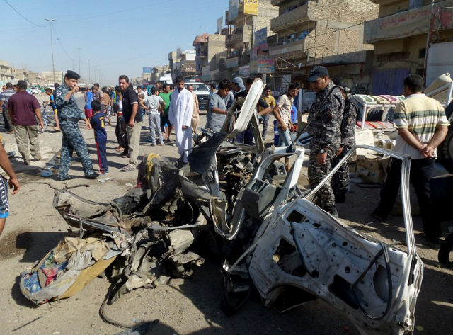 IRAQ BOMBINGS. Iraqi citizens and security forces inspect the site of a car bomb explosion in the impoverished district of Sadr City in Baghdad on July 29, 2013, after 11 car bombs hit nine different areas of Baghdad, seven of them Shiite-majority, while another exploded in Mahmudiyah to the south of the capital. AFP PHOTO/AHMAD AL-RUBAYE