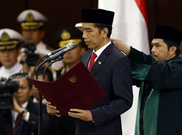 PRESIDENT JOKOWI. Joko 'Jokowi' Widodo reads the oath during his swearing-in ceremony as new Indonesian president in front of Parliament members in Jakarta on October 20, 2014. A cleric holds a copy of the Koran above his head. Photo by Adi Weda/EPA 