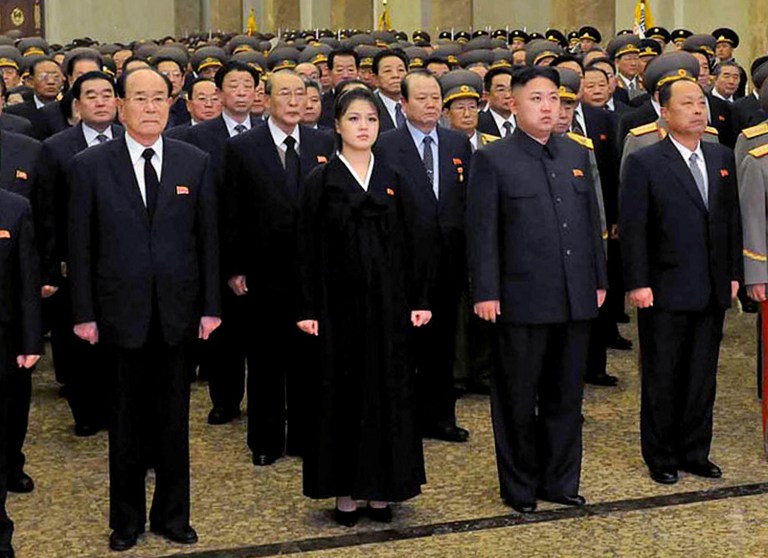 This picture taken by North Korea's official Korean Central News Agency on December 17, 2012 shows North Korean leader Kim Jong Un (centre R, front), accompanied by his wife Ro Sol Ju (centre L, front) and senior officials of the party and North Korean Army paying respect to late leader Kim Jong Il at the Kumsusan Palace in Pyongyang for the first anniversary of his death. AFP PHOTO / KCNA via KNS
