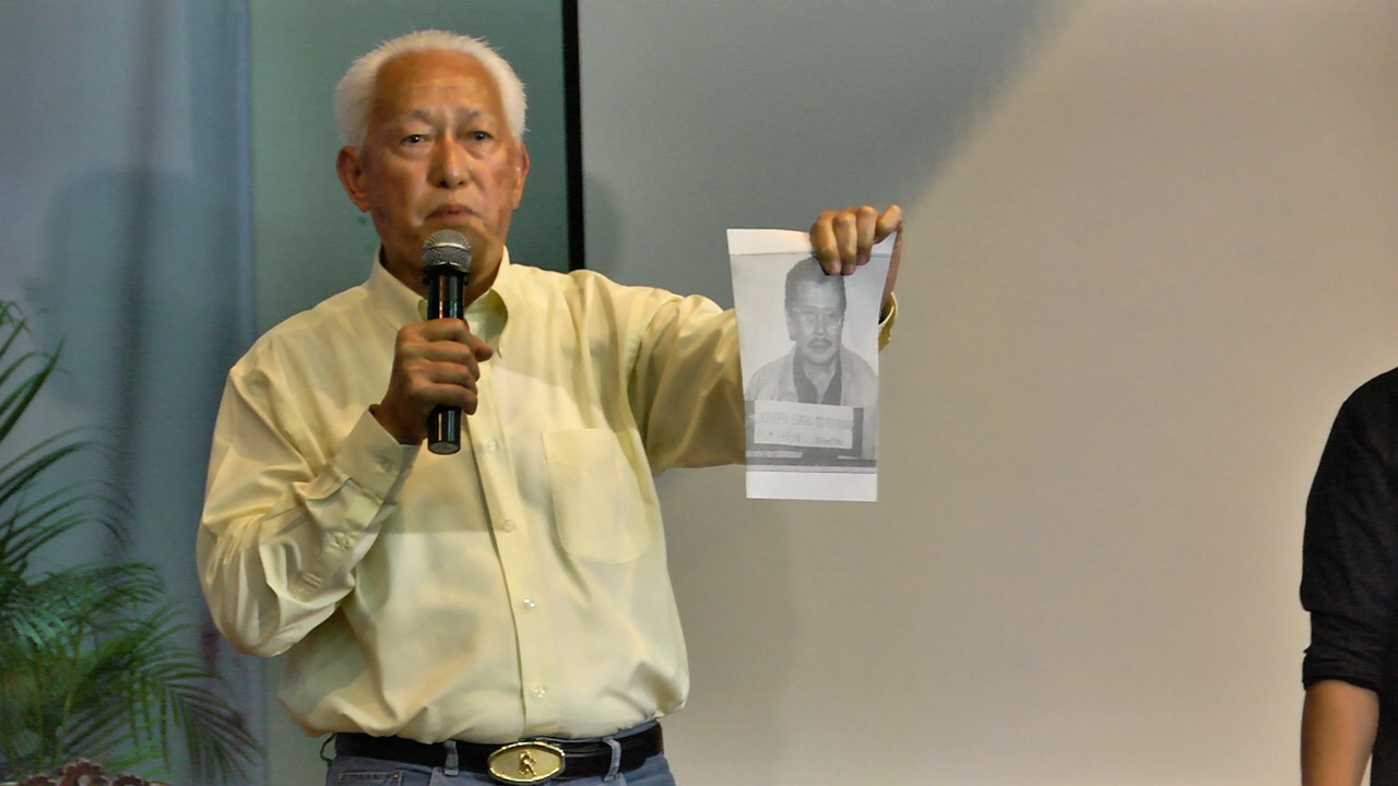 'IS THIS YOU?' Lim holds up the mug shot of Estrada during the "Thrilla in UP Manila" and says it would be a shame for Manila to have a mayor who was convicted of plunder. 