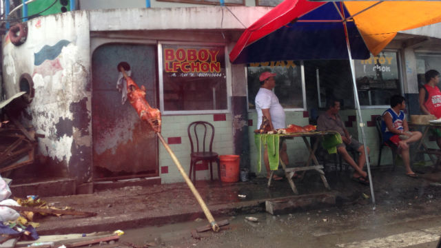 BACK TO NORMAL. Vendors sell roast lechon on the main street of Tacloban.
