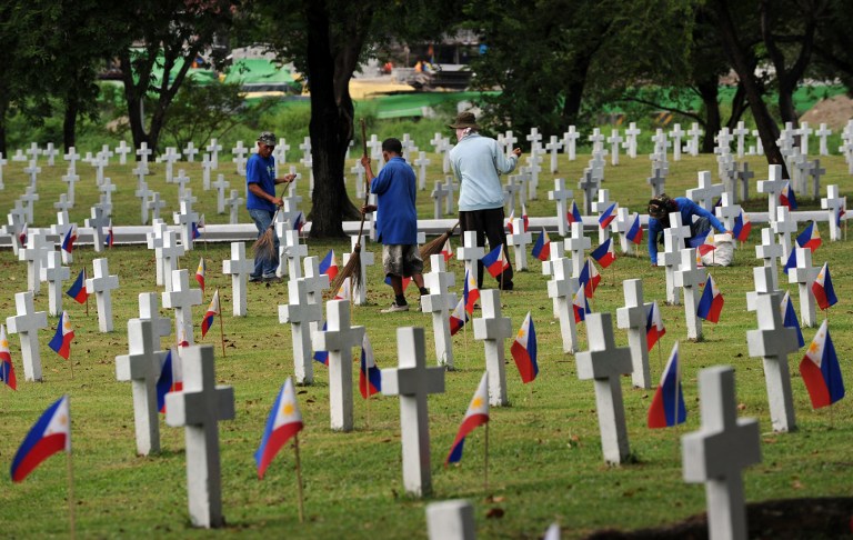 UNDAS 2012.Workers clean soldiers' graves at the heroes' cemetery in Manila on October 30, 2012, two days prior to the annual All Saint's Day. Millions of Filipinos will flock to cemeteries on November 1 and 2 around the country in a traditional commemoration of remembering their loved ones by offering flowers, candles and prayers. AFP PHOTO/TED ALJIBE