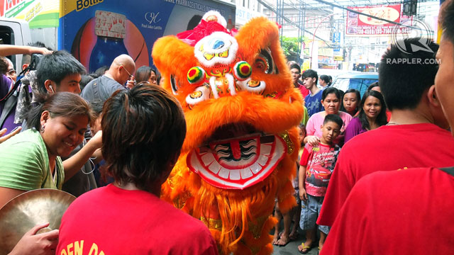 FEARSOME FACE. The dragon lion's head is meant to scare off negative energy from businesses and homes. Festival-goers, however, aren't intimidated one bit.