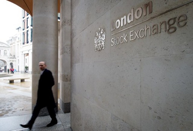 LEAVING. A man walks past the London Stock Exchange. March 2013 file photo by AFP