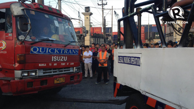 TOWED. The first violators of the Manila daytime truck ban are towed by local officials. Photo by Rappler