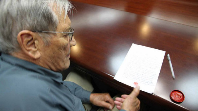 DEPORTED. A file photo taken on November 9, 2013 shows US citizen Merrill Newman inking his thumbprint onto a written apology for his alleged crimes both as a tourist and during his participation in the Korean War, while under detention in Pyongyang. Photo by KCNA via KNS/AFP 
