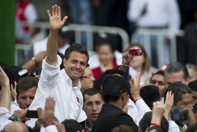 The presidential candidate for Mexico's Institutional Revolutionary Party (PRI), Enrique Peña Nieto, waves at supporters during an electoral rally in Toluca, Mexico State, on June 27, 2012. AFP PHOTO/RONALDO SCHEMIDT