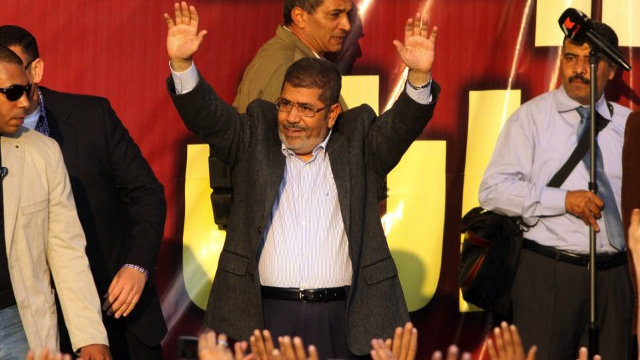 "DICTATOR" MORSI? Egypt's Islamist President Mohamed Morsi waves to his supporters in front of the presidential palace in Cairo on November 23, 2012. AFP PHOTO/STR
