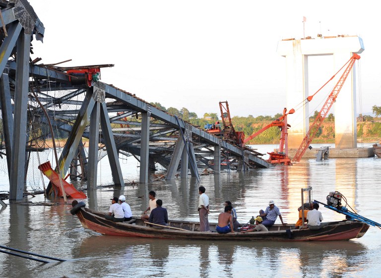 QUAKE AFTERMATH. People on a boat work near a damaged bridge in Kyauk Myaung township, east of Shwebo, following a powerful earthquake that hit Myanmar killing at least 13 people, injured dozens and sparking panic in the major central city of Mandalay on November 11, 2012. AFP PHOTO / Soe Than WIN