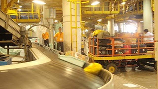 PAST SINS. Fraport presses on payment for this airport facility, which the German firm and Filipino partner built but the Philippine government took over more than a decade ago. This file photo by Lala Rimando shows manual handling at NAIA-3's baggage handling area