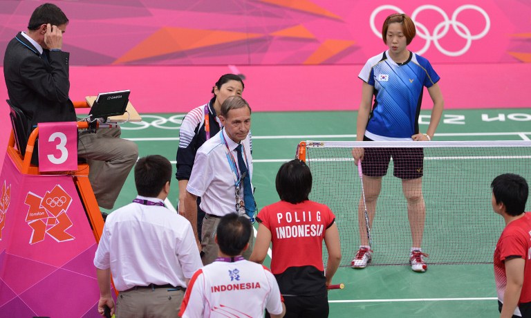 Badminton World Federation (BWF) Referee Torsten Berg (C) urges Indonesia's Greysia Polii (C) and Meilana Jauhari (bottom R) and South Korea's Ha Jung Eun (back, R) and Kim Min Jung (unseen) to play fairly in their women's doubles badminton match during the London 2012 Olympic Games in London on July 31, 2012. South Korean won the match 18-21, 21-14, 21-12. AFP PHOTO / ADEK BERRY