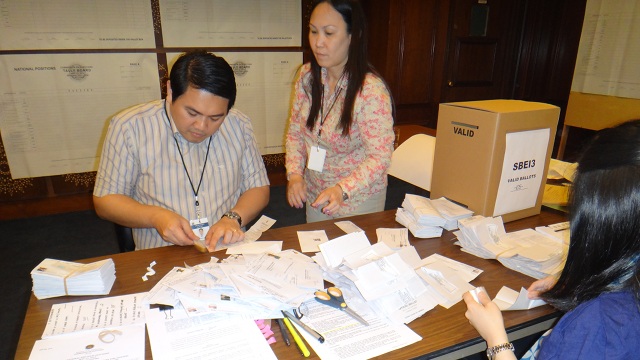 MANUAL COUNT. Deputy Consul General Tess de Vega (in blue) helps prepare the ballots for counting at the Philippine Consulate. All photos by Christina D.C. Pastor
