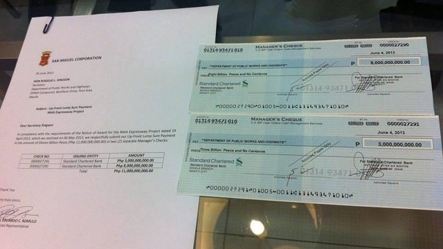 THE CHECKS. San Miguel pays the government two managers checks worth P11-billion on June 5 for the NAIA Expressway project. Photo from a tweet of PPP Center (@PPP_Ph)
