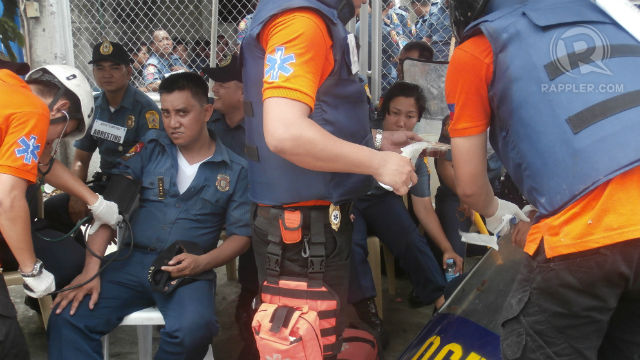 INJURED. First aid responders tend to an injured policeman following a scuffle between the police and protestors in Commonwealth Avenue, Quezon City. Photo by David Lozada/Rappler