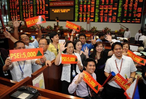 BULLISH. Traders celebrate during a ceremony marking the record high of 5,000 points reached last week at the Philippine Stock Exchange on March 6, 2012. Photo by AFP