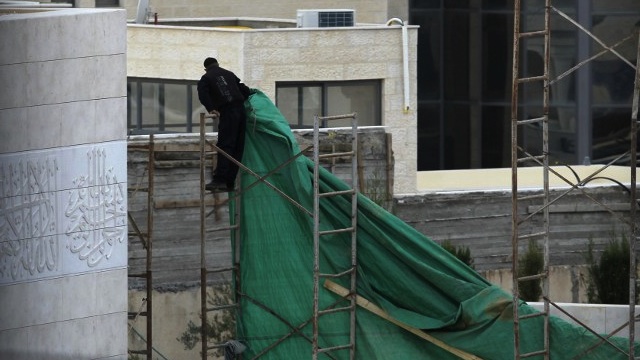 PREPARATIONS. A Palestinian worker erects plastic tarpaulin around the mausoleum of the late Palestinian leader Yasser Arafat, in the West Bank city of Ramallah, on November 24, 2012. AFP PHOTO / ABBAS MOMANI