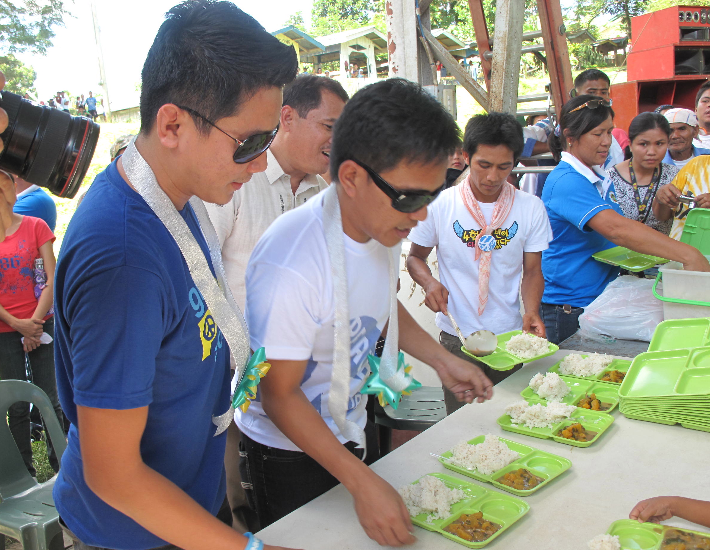 HELPING HANDS. Musicians Ebe Dancel and Datu Khomeni take part in a feeding program in Aleosan, North Cotabato. Photo by Angela Casauay.