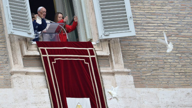 DOVE ATTACK. Children release white doves next to Pope Francis from the window of his private apartments during his Angelus prayer at St Peter's square on January 26, 2014 at the Vatican. The doves immediately came under attack by a seagull and crow. File photo by AFP 