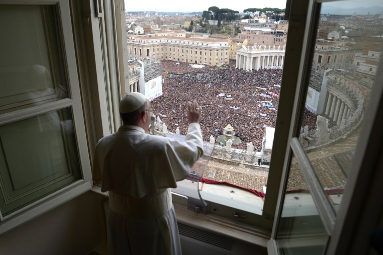 Pope Francis waves to the crowd at St Peter's square during his first Angelus prayer at the Vatican on March 17, 2013. AFP PHOTO/OSSERVATORE ROMANO