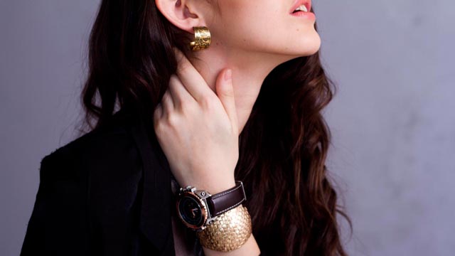 IF BLACK IS UNAVOIDABLE, lighten up your look with gold. It'll make your skin look good, too.