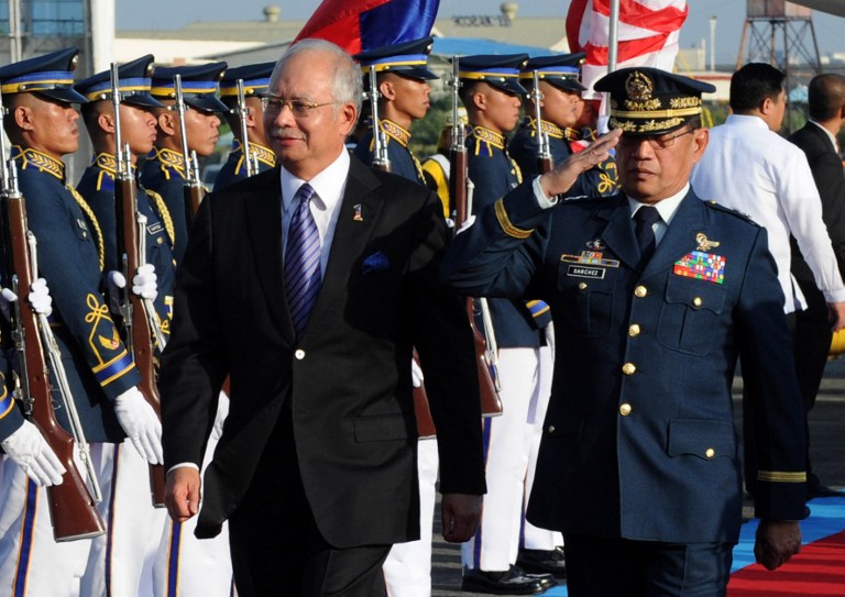 Malaysian Prime Minister Najib Razak (L) walks alongside an honor guard with Philippine Air Force MGen Renato Lorenzo Sanchez (R) upon his arrival in Manila on October 14, 2012. AFP PHOTO / JAY DIRECTO