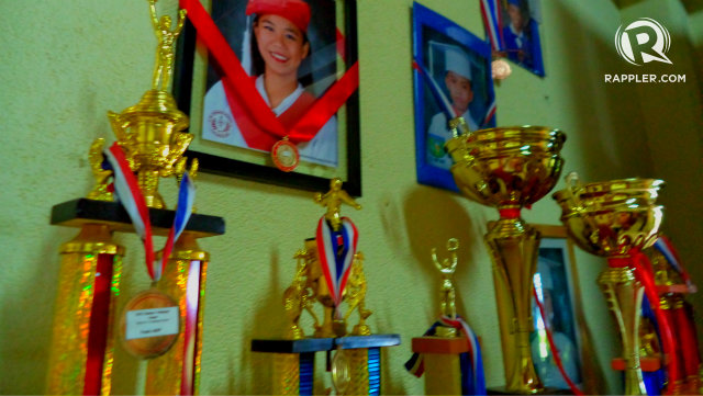 STUDY WELL. Mama Jemma proudly displays the graduation pictures and awards won by her SOS children