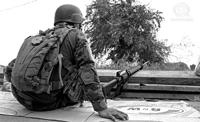 STILL WAITING. A PNP-SAF member waits at the Talon-Talon detachment, Sept.24, 2013. Photo by Paolo Villaluna