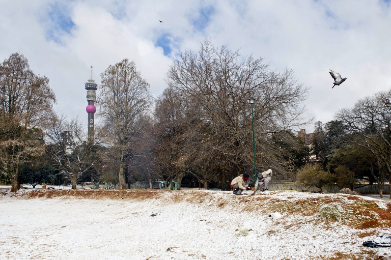 SOUTH AFRICA, Johannesburg : Two people play with snow in a park on August 7, 2012 in Johannesburg. Snow falls annually in the mountains of South Africa and Lesotho, which even hosts a ski resort. But some high-altitude border posts between the countries received so much snow today that they were forced to close. AFP PHOTO / STRINGER