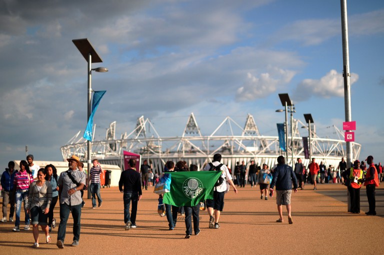 Visitors walk near The Olympic Stadium in east London on July 28, 2012, during The 2012 Olympic Games. AFP PHOTO / CARL COURT