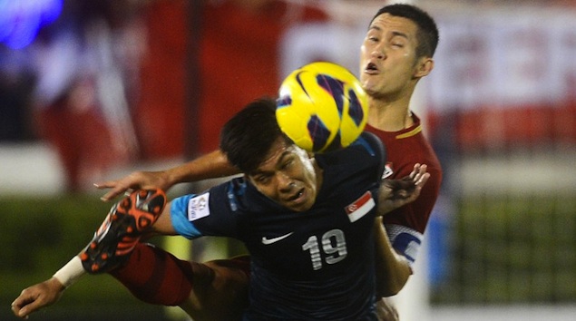 SUZUKI CUP. Thai football player Panupong Wongsa (R) battles for the ball with Mohammad Khairul Amari Kamal of Singapore (L) during their AFF Suzuki football Cup final second leg in Bangkok on December 22, 2012. Photo from AFP