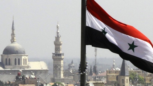ON THE EDGE. The Syrian flag flutters above Damascus. AFP PHOTO/LOUAI BESHARA