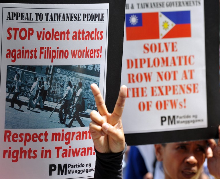 STOP ATTACKS. Protesters holding placards gesture during a protest in front of the building housing the Taiwan Economic and Cultural office (TECO), in the financial district of Manila on May 22, 2013, appealing to the Taiwanese government to ensure the safety and job security of Filipino workers in the territory. AFP photo