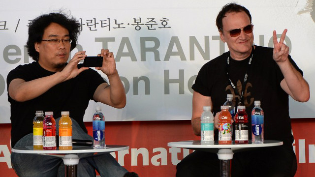 LIVELY EXCHANGE. Tarantino with fellow filmmaker Bong Joon-ho. Photo: Ted Aljibe/AFP