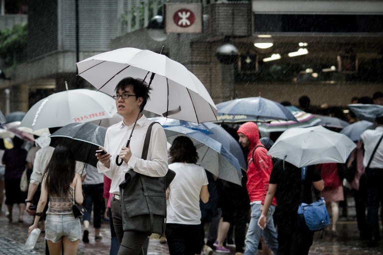 TYPHOON VICENTE. A pedestrian holding an umbrella walks past a subway station flocked with people trying to head home as strong winds and rain are brought by Typhoon Vicente in Hong Kong on July 23, 2012. AFP PHOTO / Philippe Lopez