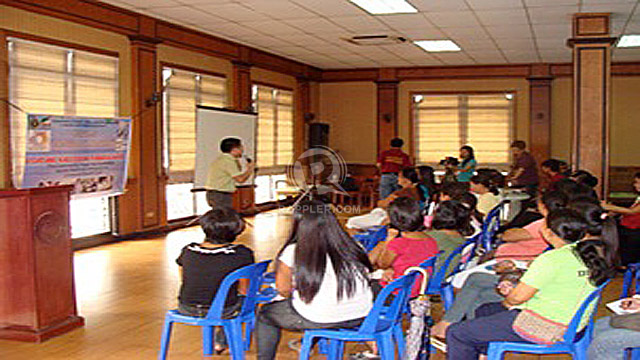 DIALOGUE WITH THE PUBLIC. Nurse Alvin Dakis talks in front of a town hall assembly in Quezon City on the importance of having a universal health care while attendees raised their concerns on local health systems. Photo by the Universal Health Care Study Group of the University of the Philippines National Institute of Health