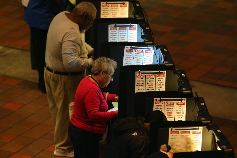 Early voters fill out their ballots as they cast their vote in the presidential election on the first day of early voting, at the Stephen P. Clark Government Center on October 27, 2012 in Miami, Florida. Joe Raedle/Getty Images/AFP