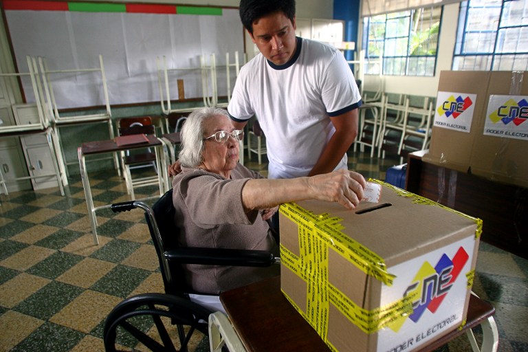 VENEZUELA DECIDES. A woman casts her vote at a polling station in Caracas on election day on October 7, 2012. TOPSHOTS/AFP PHOTO/GERALDO CASO