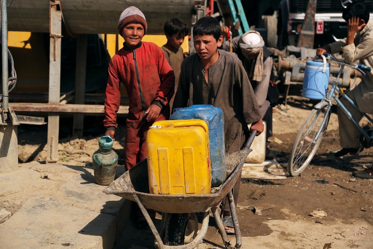 CHILD LABOR. Afghan child laborers carry water at a mechanics shop in Ghazni city, during Children's Day on June 1, 2013. Photo by Rahmatullah Alizada/AFP