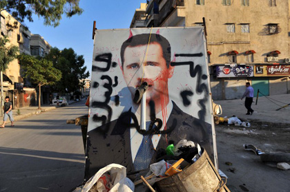 A vandalised poster of Syrian President Bashar al-Assad lies in a trash container in the northern city of Aleppo.