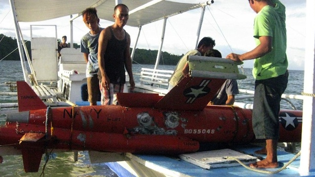 FOUND BY FISHERMEN. This handout photo released by Philippine National Police (PNP) Masbate on January 7, 2013 shows Philippine fishermen preparing to unload from their wooden boat an unmanned aerial vehicle, which Philippine naval and police authorities believe is a US drone, after it was recovered in waters off San Jacinto town, Masbate province, central Philippines. AFP PHOTO/PNP-MASBATE/PO3 ERWIN YUSI RIVERA