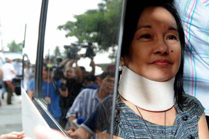 HOME. Arroyo smiles faintly as she arrives at her home in La Vista Subdivision in Quezon City. AFP Photo