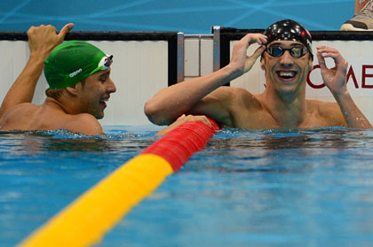 ALL SMILES: Phelps celebrates his victory in the 100m butterfly while silver medalist Chad le Clos looks on. Le Clos beat Phelps by five hundredth of a second in the 200m butterfly.
