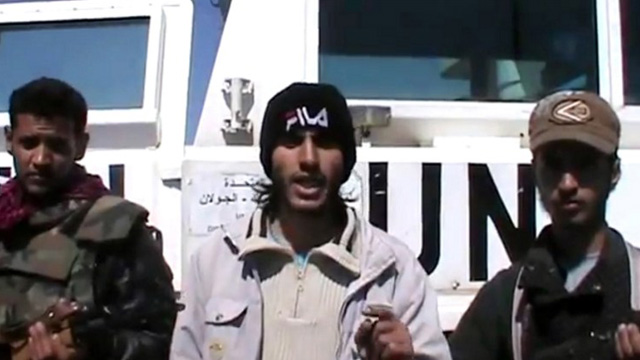 SYRIAN KIDNAPPERS. Screen grab taken from a video uploaded on YouTube on March 6, 2013, allegedly shows armed fighters standing in front of a United Nations Disengagement Force (UNDOF) vehicle in the Golan Heights between Syria and Israel. AFP PHOTO/YOUTUBE