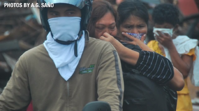 DEATH. Passersby cover their noses to protect themselves from the smell of death. Photo by AG Saño